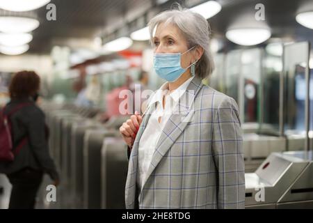 Femme âgée dans un masque à l'entrée de la station de métro Banque D'Images