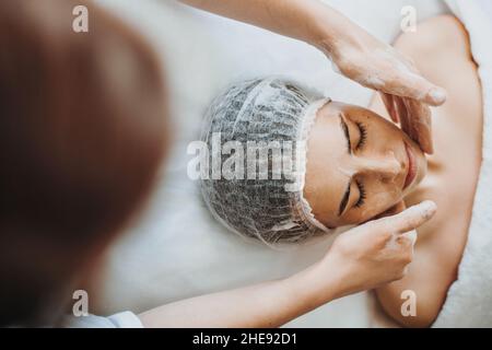 Portrait en gros plan d'un client qui reçoit un gommage nettoyant au salon de beauté.Visage de beauté.Procédure de beauté de cosmétologie.Dermatologie, cosmétologie. Banque D'Images