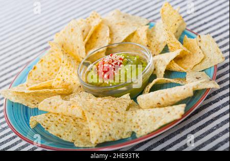 Nachos avec guacamole sur plateau bleu Banque D'Images