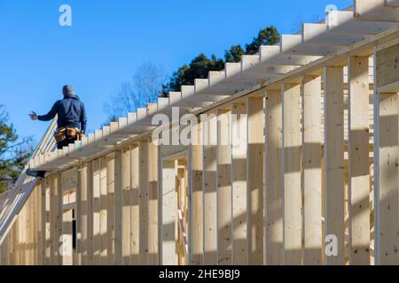 Constructeur à l'intérieur de bois homme en clouant des poutres en bois travaux de construction à l'aide d'un marteau pneumatique Banque D'Images