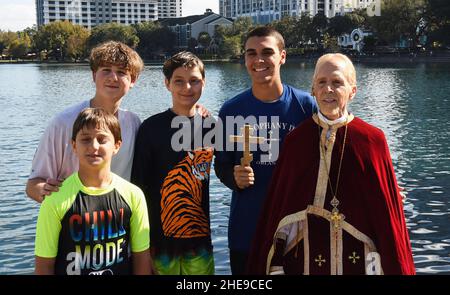 Orlando, États-Unis.09th janvier 2022.Isaac Abdelmessih (en tenant la croix) pose avec FR.John Hamatie et les autres plongeurs lors de la plongée transversale annuelle Epiphany organisée par l'église orthodoxe de Saint-George au centre-ville d'Orlando.La célébration honore le baptême de Jésus-Christ et il est dit que la personne qui récupère la croix recevra la bonne chance pour le reste de l'année.Crédit : SOPA Images Limited/Alamy Live News Banque D'Images