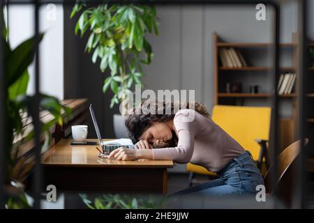 Femme d'affaires fatiguée dormant sur le bureau au bureau épuisé sans motivation avec des tâches monotones besoin de repos Banque D'Images