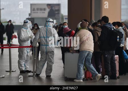 NANJING, CHINE - 10 JANVIER 2022 - les travailleurs de la prévention des épidémies vérifient les informations sanitaires des passagers un par un à l'entrée de Nanjing South Railw Banque D'Images