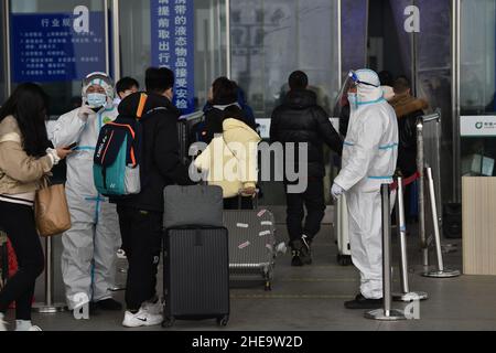 NANJING, CHINE - 10 JANVIER 2022 - les travailleurs de la prévention des épidémies vérifient les informations sanitaires des passagers un par un à l'entrée de Nanjing South Railw Banque D'Images