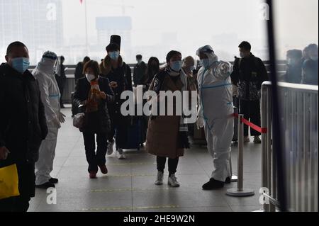 NANJING, CHINE - 10 JANVIER 2022 - les travailleurs de la prévention des épidémies vérifient les informations sanitaires des passagers un par un à l'entrée de Nanjing South Railw Banque D'Images