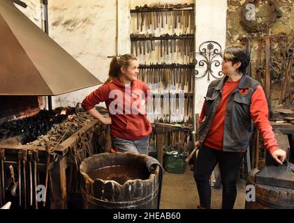 16 décembre 2021, Saxe, Leipzig: Les deux filles de Kunstschmied Althammer, maître métallurgiste et chef actuel de la forge, Elisabeth Althammer-Kluge (r) et graphiste et compagnon de métal Claudia Süßmeyer se tiennent près du feu de forge tout en travaillant sur un bar pour une porte.Althammer, qui a fondé sa forge artistique il y a 45 ans, est ravi que ses deux filles aient pris en charge l'entreprise de l'artisan et qu'il puisse lui-même fournir des conseils basés sur ses nombreuses années d'expérience.(À dpa KORR: 'L'artisanat reste dans la famille - les filles prennent le contrôle de la forge d'art') photo: Waltraud Grubitzsch/dpa-Zen Banque D'Images