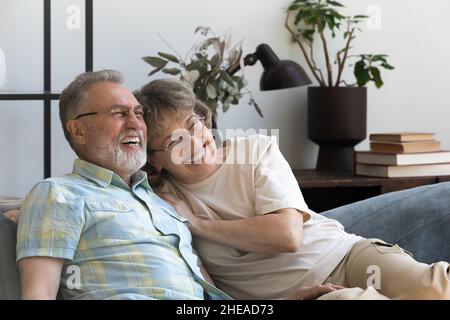 Un couple affectueux et heureux de 60s personnes se reposant sur un canapé. Banque D'Images