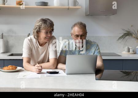 Un couple d'âge moyen heureux planifiant un budget mensuel. Banque D'Images