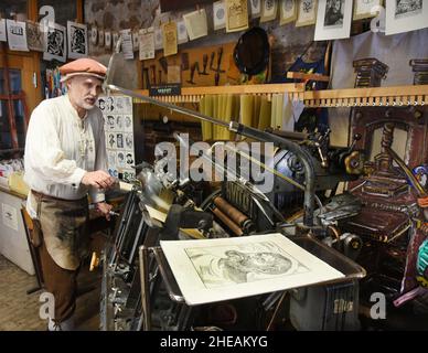 07 janvier 2022, Saxe-Anhalt, Wittenberg Lutherstadt: Dans sa salle d'impression historique de Cranach Hof Schlossstra§e 1, Andreas Metschke imprime sur une presse à plateau.Le classeur principal et l'imageuse de plaques formée donnent aux visiteurs du monde entier un aperçu des anciennes techniques d'impression dans la cour historique où le peintre Lucas Cranach The Elder (1472-1553) a eu sa maison, un atelier de peinture, une pharmacie et aussi une imprimerie.Né il y a 550 ans à Kronach (Bavière), Cranach aurait peint le réformateur Martin Luther dans les chambres en 1508 et imprimé sa traduction du B Banque D'Images
