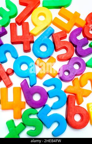 Alphabet coloré et aimants de nombre dispersés sur une surface blanche, favorisant l'apprentissage de la petite enfance et les activités de jeu Banque D'Images
