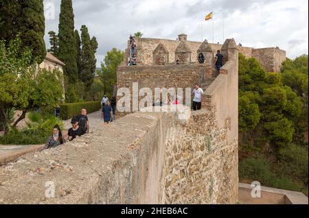 Personnes explorant les remparts défensifs Castillo de Giralfaro château murs, Malaga, Andalousie, Espagne Banque D'Images