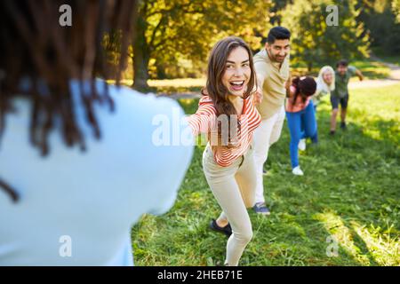 Jeune équipe de démarrage faisant un exercice de renforcement d'équipe tenant les mains en été dans le parc Banque D'Images