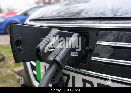 Recharge DE biens LONGUE portée MG EV à un point de charge de Genie à Romsey Hampshire.Gros plan du badge MG ouvert avec le chargeur branché. Banque D'Images