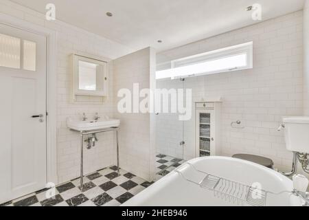 Salle de bains adorable avec plancher en damier noir et blanc Banque D'Images