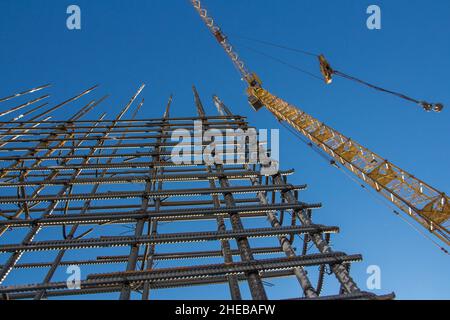 Une base de barre d'armature en acier renforcé et une grue de tour contre le ciel bleu.Raccords métalliques pour béton armé.Construction de bâtiments.La méta Banque D'Images