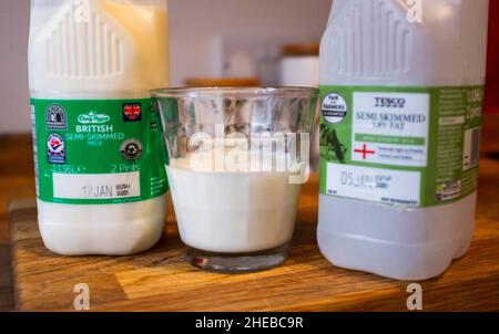 Des cartons de lait de supermarché et un verre de lait demi-écrémé avec des dates d'utilisation montrant le Royaume-Uni photo prise par Simon Dack Banque D'Images