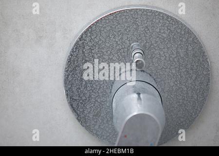 Robinet mélangeur de douche calcifiée sale, robinet avec tartre, plaque d'eau, douche chromée, photo rapprochée. Banque D'Images