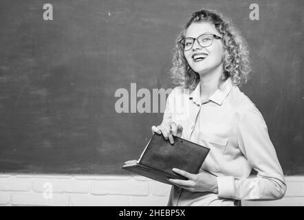 Professeur meilleur ami des apprenants.Femme enseignante devant le tableau de surveillance.Passionné par la connaissance.Pédalo tenir le livre et expliquer Banque D'Images