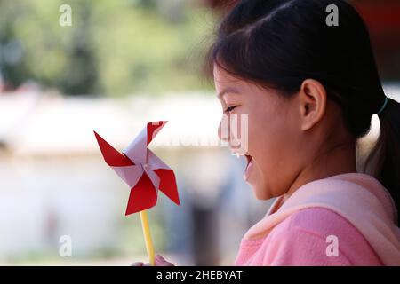 Les filles asiatiques jouent le jouet de moulin à vent dans le très heureux pour le design dans votre concept de travail. Banque D'Images