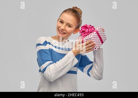 adolescente souriante en pull-over avec boîte cadeau Banque D'Images