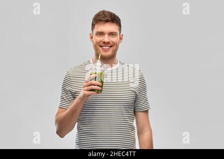 homme buvant du smoothie vert dans une tasse jetable Banque D'Images