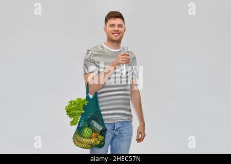 homme avec de la nourriture dans le sac et de l'eau dans une bouteille en verre Banque D'Images