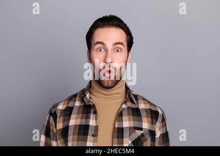 Photo de charmant choqué gars habillé damier chemise grands yeux isolé couleur gris fond Banque D'Images