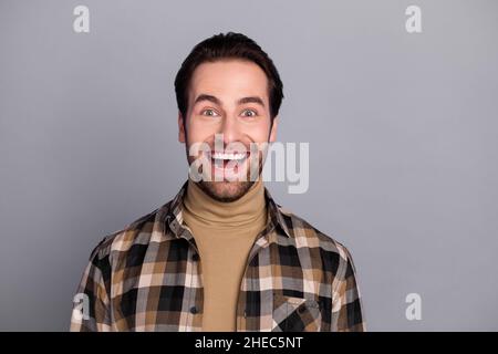 Photo de drôle impressionné homme porter chemise à carreaux sourire bouche ouverte isolé couleur grise fond Banque D'Images