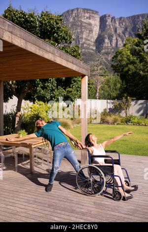 Femme afro-américaine en fauteuil roulant dansant avec son mari à l'extérieur Banque D'Images
