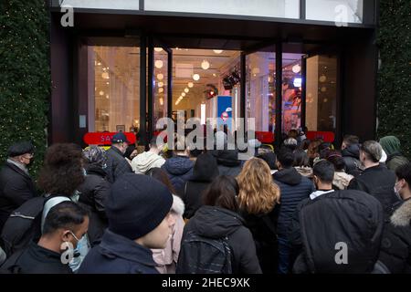 Les gens entrent dans le grand magasin Selfridges au moment de l'ouverture le lendemain de Noël dans le centre de Londres alors que les acheteurs se rassemblent sur Oxford Street. Banque D'Images