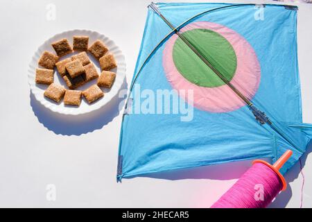 Barres chikki aux arachides écrasées avec Kite et fil de bobine avec fond blanc.Makar sankranti, uttarayan, pongal, Lohri affiche pour écrire gr Banque D'Images