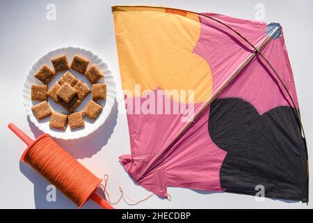 Barres chikki aux arachides écrasées avec Kite et fil de bobine avec fond blanc.Makar sankranti, uttarayan, pongal, Lohri affiche pour écrire gr Banque D'Images