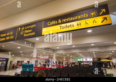 Panneau / panneaux sur le plafond du salon de départ de l'aéroport de Gatwick Nord terminal, y compris les portes et numéros de portes / toilettes / toilettes / toilettes / toilettes, toilettes, toilettes et cafés et restaurants à l'étage. Londres, Royaume-Uni (128) Banque D'Images