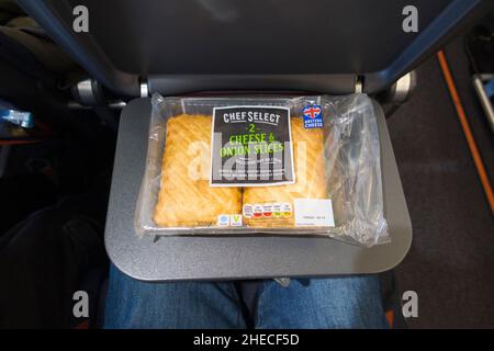 Fromage et oignon pasty, pasties / remplissage de nourriture avec beaucoup d'énergie, sur une table de plateau de siège, sur un Airbus A320 ou A319 avion / avion.Une partie d'un panier repas pour un passager qui a pris l'en-cas à bord du vol Easyjet pour une partie d'un repas indépendant.(128) Banque D'Images