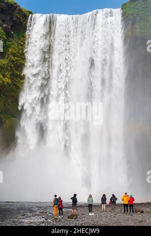 Islande, région soudanaise, Skogar, touristes en face de Skogafoss Banque D'Images