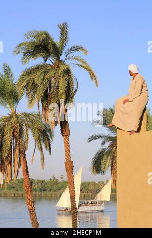 Égypte, haute Égypte, vallée du Nil, El Kab, croisière entre Esna et Assouan depuis dahabieh Luxor avec palmiers en premier plan et la maison de l'architecte anglais et égyptologue Somers Clarke Banque D'Images