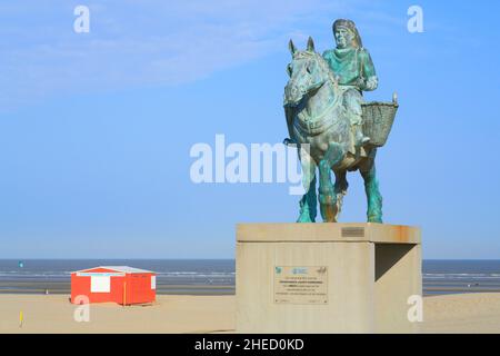 Belgique, Flandre Occidentale, Koksijde, Oostduinkerke, plage,Statue d'un pêcheur local de crevettes à cheval (patrimoine culturel immatériel de l'humanité) et en arrière-plan la station de premiers secours sur la mer du Nord Banque D'Images