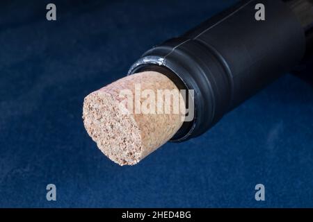 Le col d'une bouteille avec un bouchon sur fond bleu.Verrerie pour le stockage du vin Banque D'Images