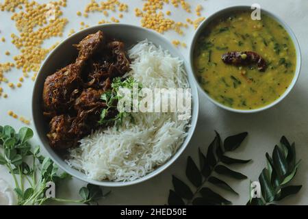 Rôti de poulet sec de style Kerala et curry de lentilles préparés avec des feuilles de fenugrec servies avec du riz basmati.Un repas combiné sain appelé riz avec c Banque D'Images