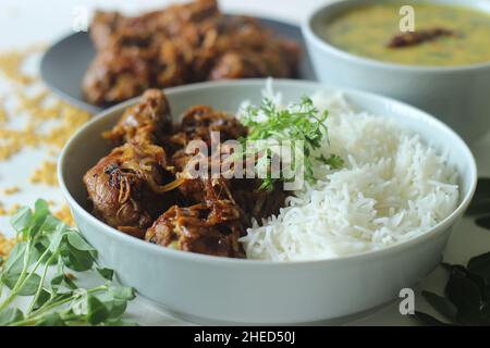 Rôti de poulet sec de style Kerala et curry de lentilles préparés avec des feuilles de fenugrec servies avec du riz basmati.Un repas combiné sain appelé riz avec c Banque D'Images