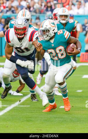 Dimanche 9 janvier 2022 ; Miami Gardens, FL États-Unis; Dolphins de Miami Running Back Duke Johnson (28) court avec le ballon alors qu'il est poursuivi par Deatrich Wise (91), le défenseur des Patriots de la Nouvelle-Angleterre, lors d'un match de la NFL au Hard Rock Stadium. Les dauphins ont battu les Patriots 33-24. (Kim Hukari/image du sport) Banque D'Images