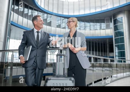 Deux entrepreneurs souriants se tenant au terminal de l'aéroport Banque D'Images