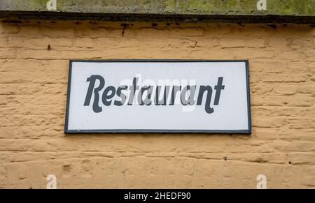 Panneau de restaurant sur un ancien bâtiment à la façade beige Banque D'Images
