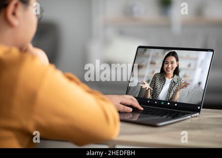 Enfant méconnaissable ayant un chat vidéo avec un tuteur Banque D'Images