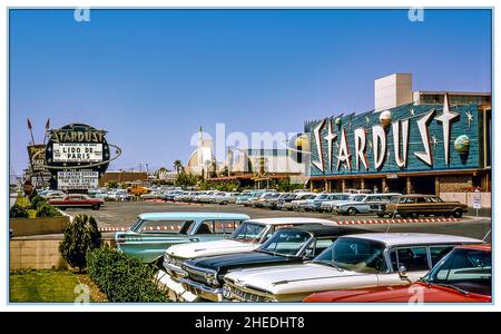 Carte postale rétro de Las Vegas 1950s /1960s montrant l'hôtel Stardust et les voitures de casino garées de l'époque avec son panneau rond distinctif en bord de route.L'édifice et les panneaux routiers datent de l'ouverture de l'hôtel en 1958.'The Stardust' Lido de Paris boîte de nuit revue vintage carte postale rétro 1950s /1960s Nevada USA Banque D'Images