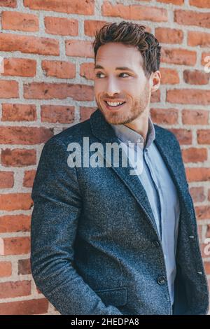 Jeune homme d'affaires portrait de tête.Homme d'affaires caucasien modèle portant blazer bleu et chemise sourire à l'écart.Recadrage vertical Banque D'Images