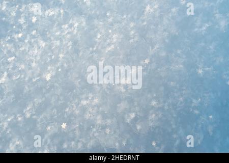 De beaux cristaux de flocons de neige brillent dans les rayons du soleil, sur la neige moelleuse, un jour gelé.Copier l'espace.Arrière-plan.Vue de dessus. Banque D'Images