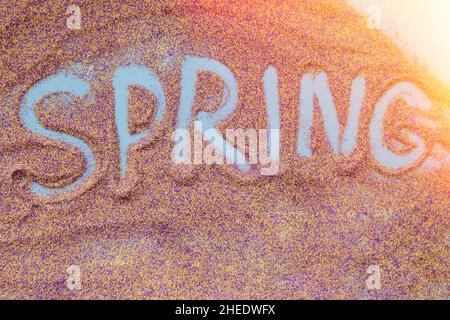 Spring Hand écrit concept sur sable gros plan.Sable coloré.Concept de texte de printemps créatif.Vue de dessus. Banque D'Images