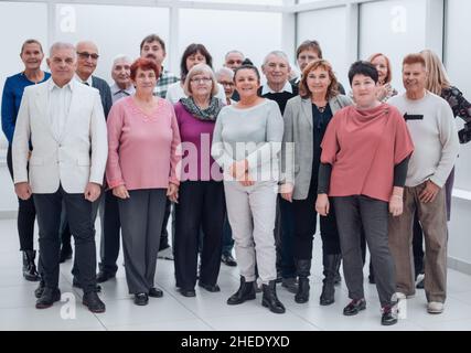 Groupe décontracté de personnes mûres souriantes debout dans un hall Banque D'Images