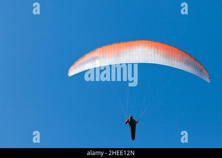 Depuis le dessous du parapente volant sur le parachute dans l'océan bleu. Banque D'Images